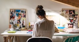 Young businesswoman at her desk in home studio.
