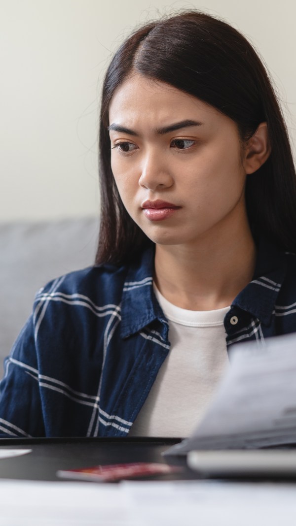 Young Asian woman holding credit card and debt letter