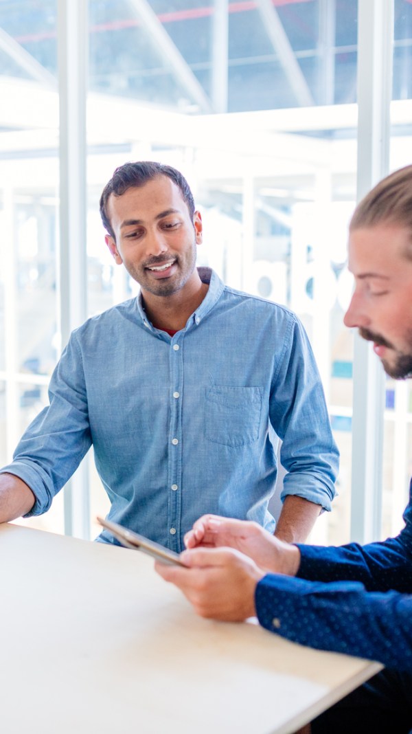 Two male co-workers discuss IRS payment plans in a conference room.