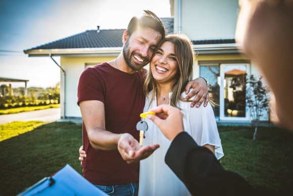 Happy couple receiving keys from realtor.