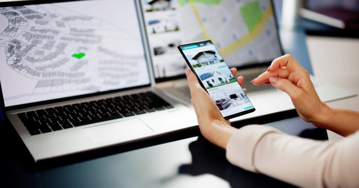 Woman with multiple screens open looking at neighborhoods and real estate listings.