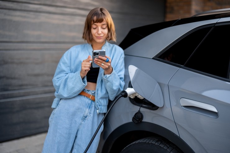 Young woman charger her electric vehicle.