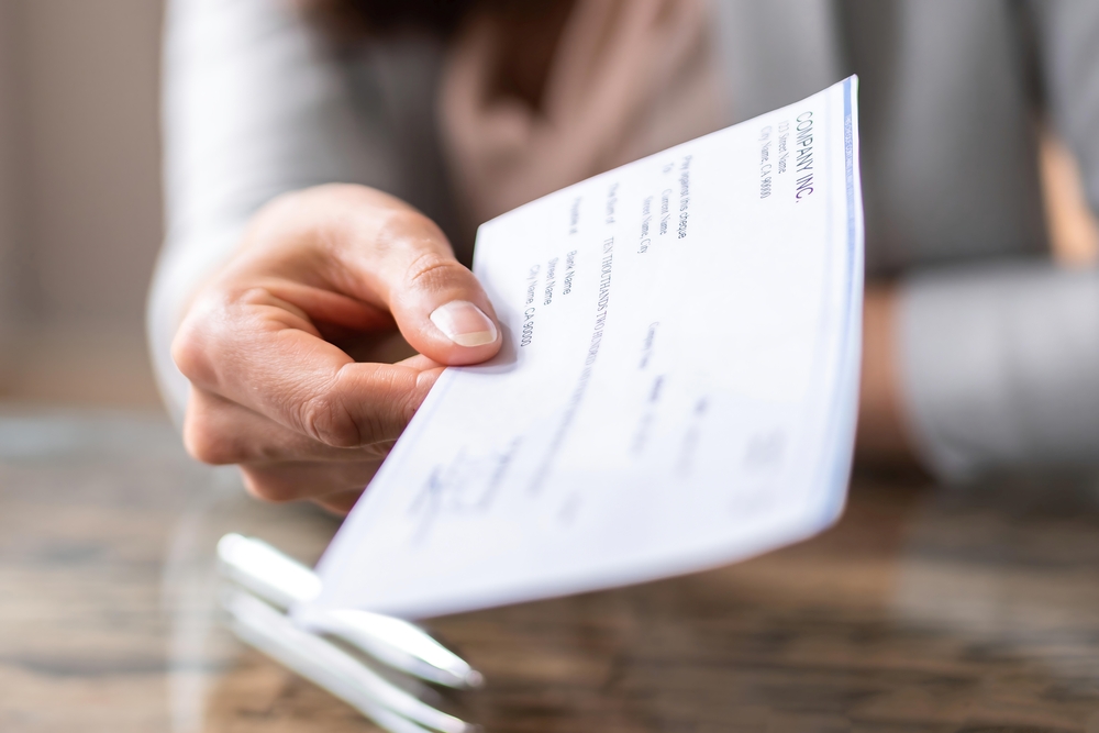 Employer handing over paycheck.