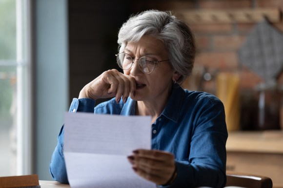 Mature woman reading a document in her kitchen