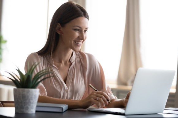 Young caucasian woman doing research on her laptop.