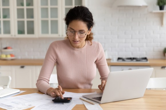 Woman sitting at kitchen table working on taxes