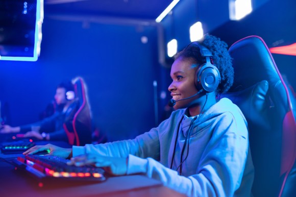Young Black woman playing video games while streaming.