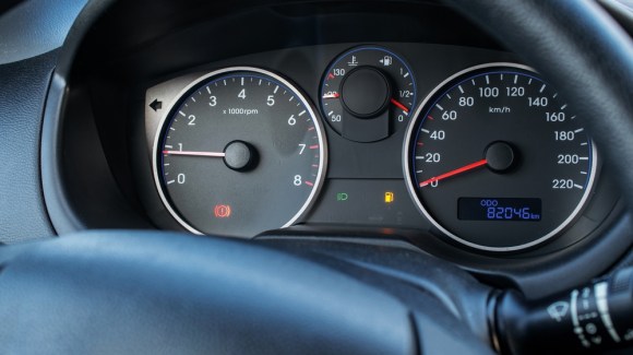 Close-up of vehicle dashboard showing mileage reading.