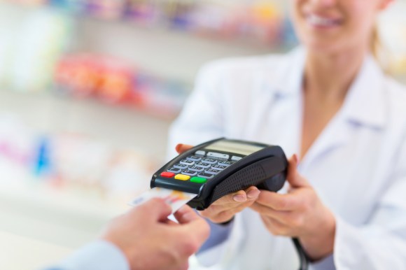 Close-up of someone paying with credit card at a pharmacy.