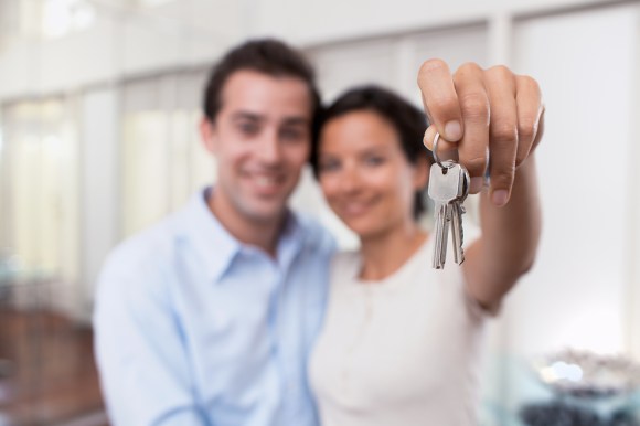 Young couple holding house keys.