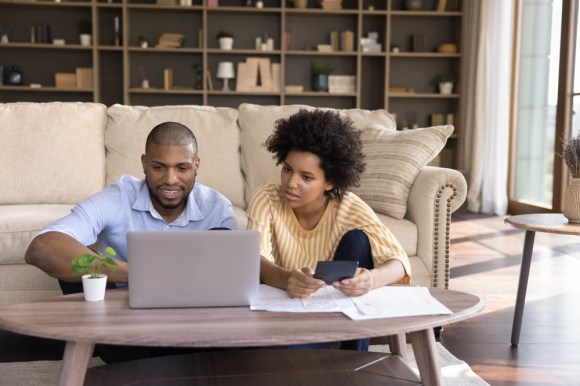 Millennial Black couple doing their taxes together.