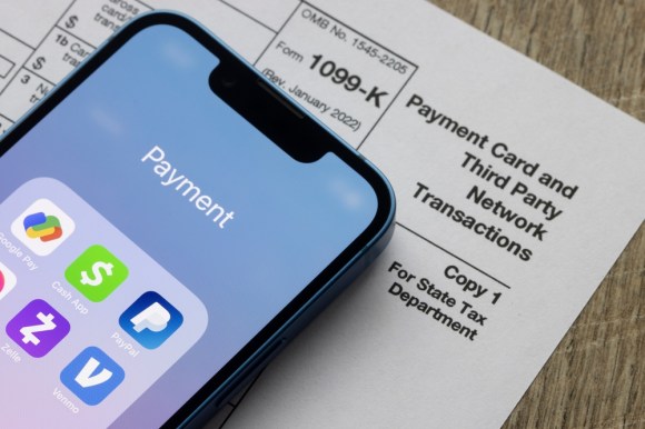 Payment apps like PayPal and Venmo are seen on an iPhone on top of Form 1099-k.