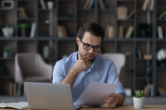 Man looking at a document in deep thought.