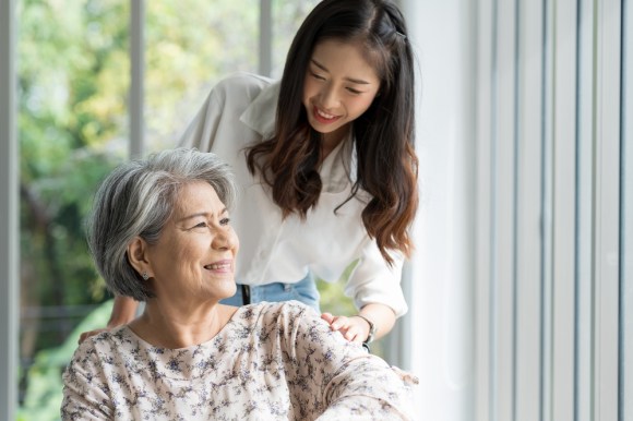 Young Asian woman assisting an elderly woman.