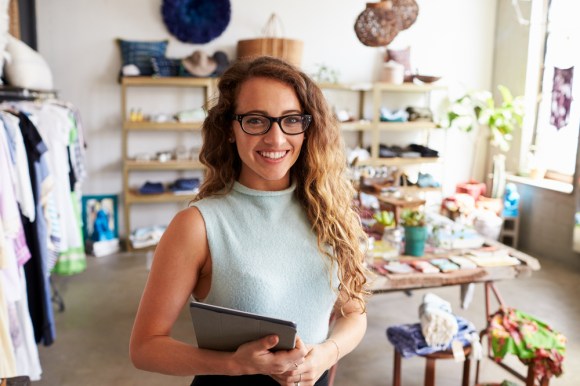Female business owner holding a tablet in a clothing store.