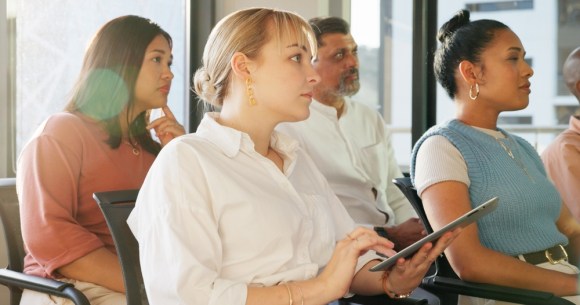 Woman sitting in the audience at a seminar.