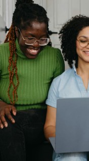 Two gen z people looking at a laptop
