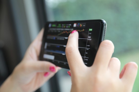 Close-up of smartphone with someone trading stocks online.