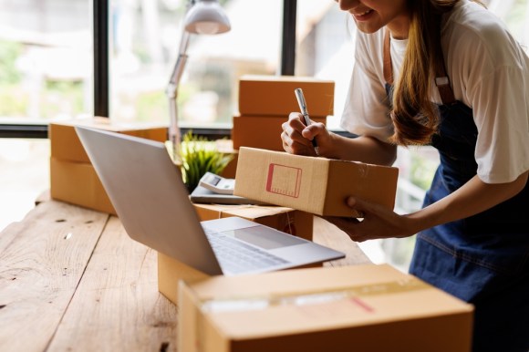 Young business owner prepping products for shipping.