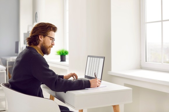 Man tracking information in a spreadsheet.