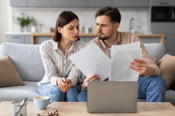 Confused couple reviewing documents.