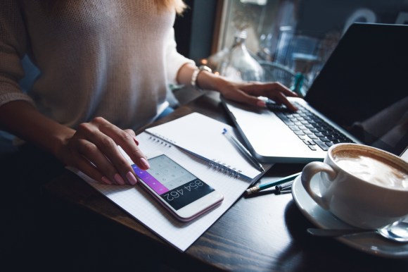 Woman using her phone calculator.
