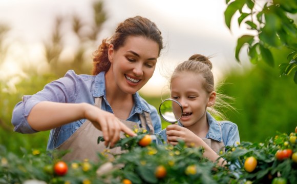 Mother and daughter tending to a vegetable garden.
