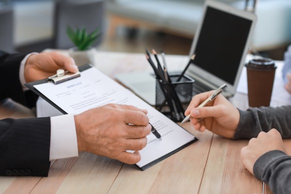 Close-up of woman signing legal document