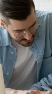 dad helping daughter with school homework, sitting together at table