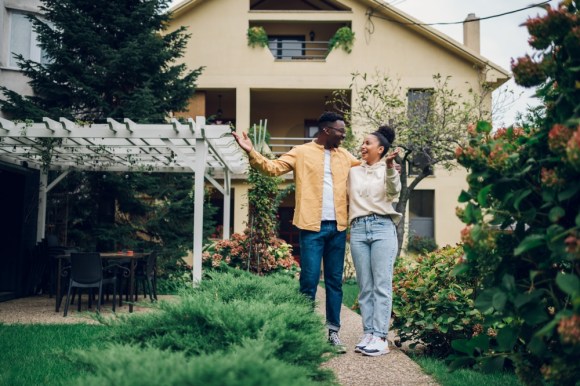 New homeowners standing outside their house