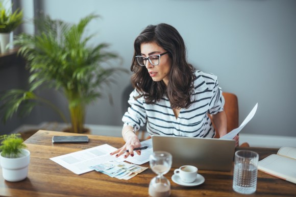 Business owner reviewing documents at her desk.